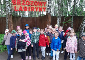 dzieci pozują do zdjęcia przed wejściem do brzozowego labiryntu