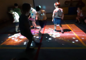 ciemno, dzieci chodzą po macie, w świetle, w kształcie gwiazd z FUN FLOOR