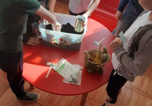 dzieci przygotowują zielony ogródek, sypią ziemię do puszek