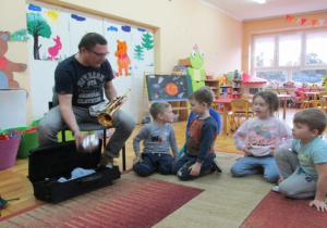 tata pokazuje dzieciom trąbkę