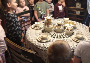 dzieci w domu rodzinnym Św. Maksymiliana - pokój z dużym okrągłym stołem, przykrytym białą serwetą i ustawionym serwisem kawowym