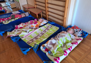 maluszki śpią na leżaczkach pod kolorowymi kocykami
