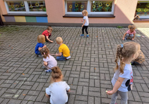 maluszki rysują kredą na tarasie przedszkolnym