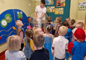 dzieci obserwują w jaki sposób wyrabiana jest wata cukrowa