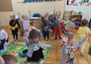 dzieci tańczą i machają rękami w górze