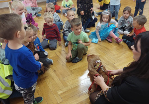 dzieci przyglądają się pieskowi i jego opiekunce