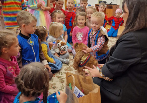 chłopiec głaszce psa a wokoło siedzą dzieci