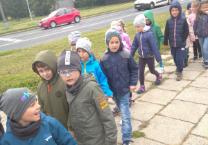 przedszkolaki maszerują parami prawą stroną chodnika