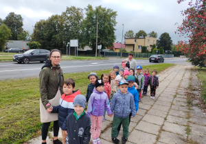 przedszkolaki z nauczycielką stoją na chodniku