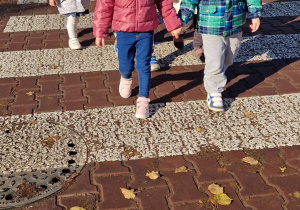 dzieci idą parami po pasach