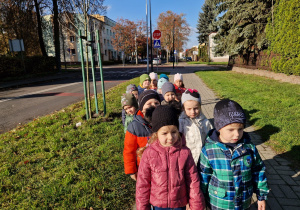 dzieci idą parami po chodniku