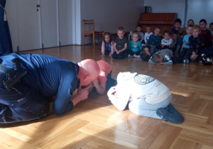 policjant demonstruje właściwe zachowanie dzieciom podczas ataku psa na człowieka