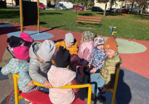 dzieci bawią się na osiedlowej karuzeli