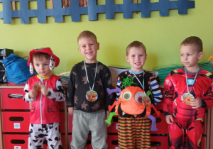 chłopcy przebrani za postaci z bajek z okolicznościowymi medalami zawieszonymi na szyi
