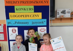 grupa uczestników konkursu z przedszkola pod tablicą pozuje do zdjęcia