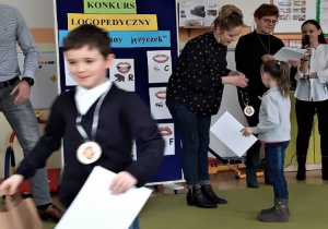 powrót z dyplomem i medalem zawieszonym na szyi chłopca