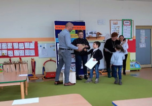 odbiór nagrodycprzez chłopca a dziewczynka odbiera dyplom od pani dyrektor