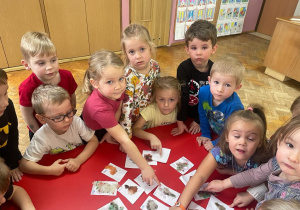 dzieci oglądają swoje woskowe obrazki, umieszczone na białych karteczkach