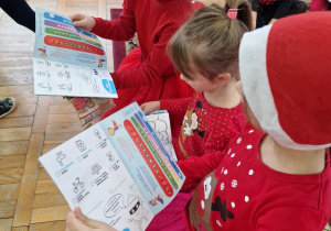 przedszkolaki oglądają otrzymane książeczki - kolorowanki od Mikołaja