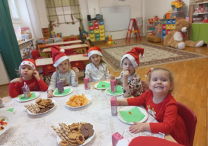 dziewczynki w czerwonych ubraniach piją soczek podczas słodkiego poczęstunku