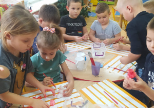 przedszkolaki malują farbami figurki zrobione za śniegu
