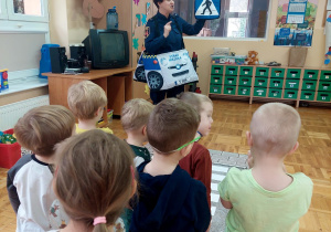strażniczka miejska pokazje dzieciom znak drogowy