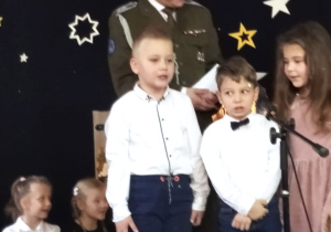 troje przedszkolaków śpiewa kolędę wraz ze starszym sierżantem Marcinem Kowalczykiem z 15 Brygady Wsparcia Dowodzenia w Sieradzu