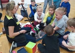 opiekunka psa opowiada o opiece nad psem siedząc wśród dzieci