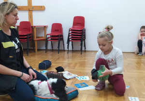 dziewczynka uczy się sprzątania odchodów psa