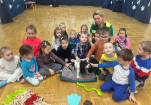 dzieci z psem i jego opiekunką pozują do zdjęcia