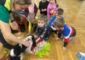 przedszkolaki chowją przysmaki dla psa w jego zabawce