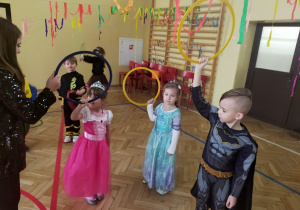 dzieci tańczą z dużymi, kolorowymi kołami