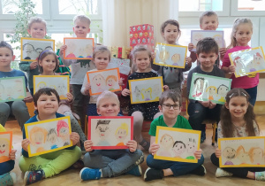 przedszkolaki z grupy VIII trzymają narysowane portrety babci i dziadka