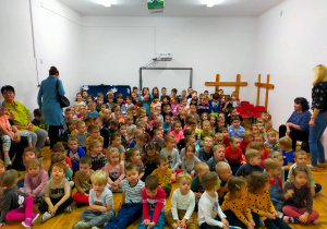 przedszkolaki z całego przedszkola siedzą na sali gimnastycznej