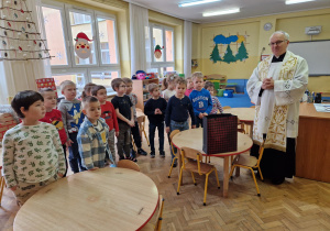 ksiądz modli się z dziećmi