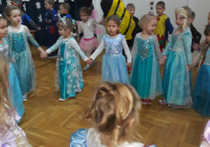dziewczynki tańczą w dużym kole trzymając się za dłonie