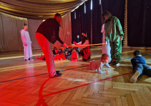 zabawa sprawnościowa - dzieci przechodzą pod przeszkodą