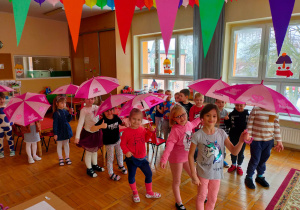 dzieci tańczą z parasolkami