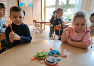 przedszkolaki pokazują pomarańczowe szczoteczki do mycia zębów jakie otrzymali