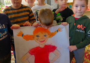 chłopcy trzymają duży karton z narysowaną Pippi Langstrumpf