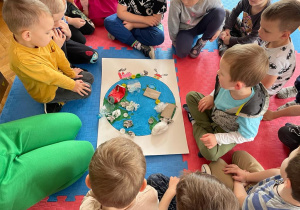 przedszkolaki w sali wykonują pracę plastyczną o zaśmieconej planecie