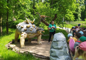przedszkolaki słuchają przewodniczki i jej wiadomości o dinozaurach