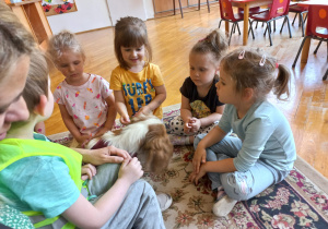 Molly podchodzi do siedzących dzieci