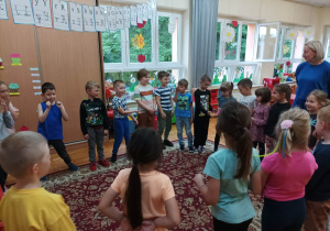dzieci stoją w kole z nauczycielką