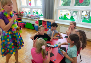 mama Antka instruuje dzieci siedzące przy stoliku