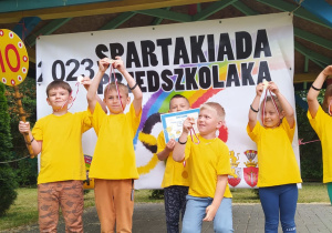 przedszkolaki pokazują medale podnosząc je do góry