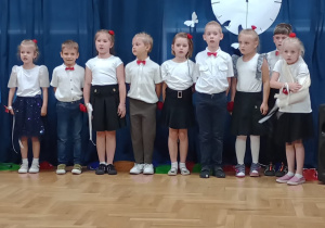 starszaki stoją w szeregu i śpiewają piosenkę