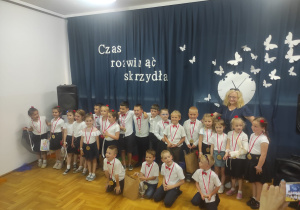 grupa starszaków z nauczycielką pozuje do zdjęcia grupowego
