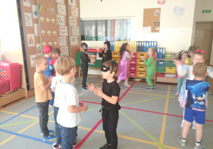 przedszkolaki tańczą w parach i klaszczą w dłonie