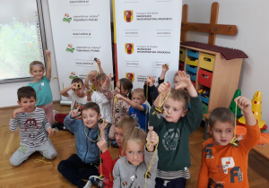 dzieci z grupy VII z motylami z szyszki na sznurku